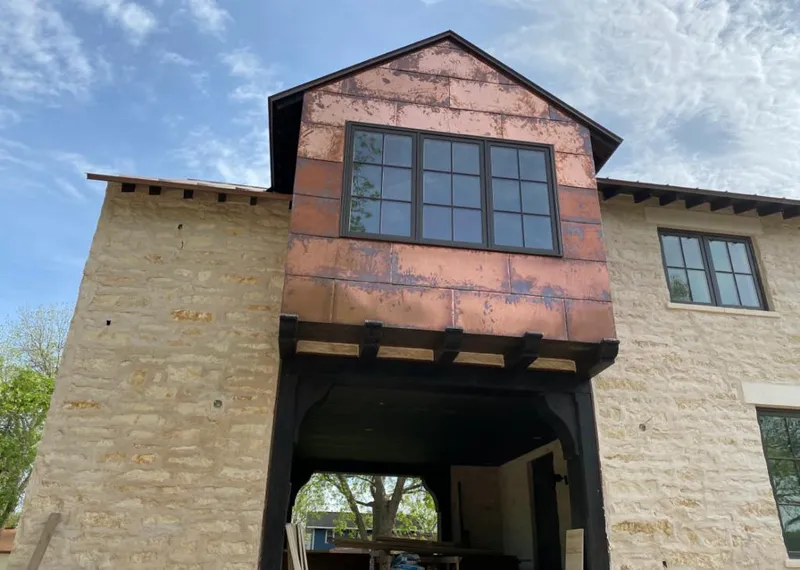 Copper metal panel facade on a stone building for Skylight Installation in Callaway